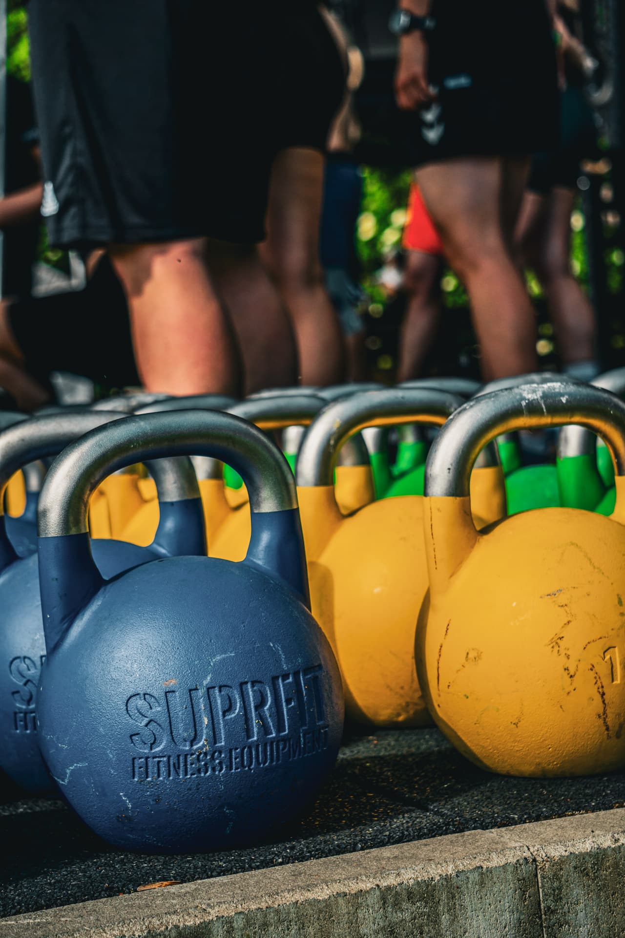 Suprfit-Kettlebells in Reihe beim Outdoor-Training des Nature Warriors Bootcamps